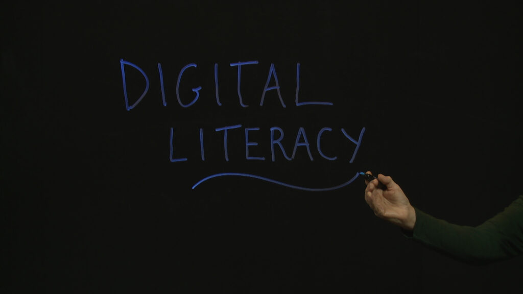 The words Digital Literacy handwritten on a Lightboard glass